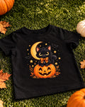 Black kids Halloween t-shirt with a black cat in an orange bow sitting on a jack-o'-lantern under a crescent moon
