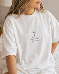Woman wearing a white oversized t-shirt with a small cross and the words the way, the truth, the life