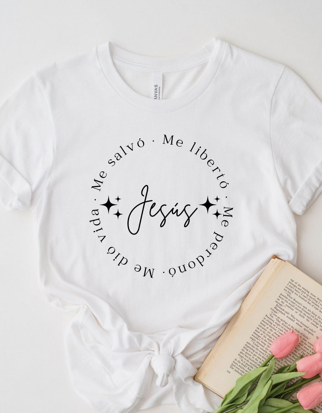 White t-shirt flat lay printed with a circle of text around the word Jesús