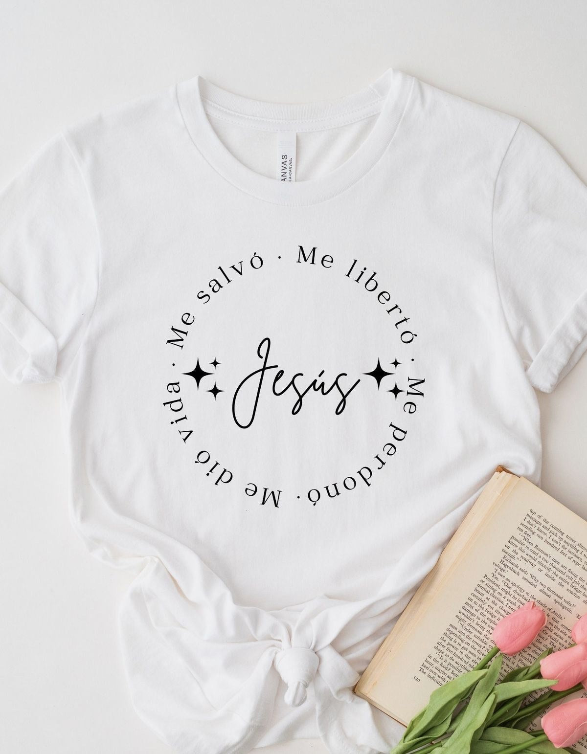 White t-shirt flat lay printed with a circle of text around the word Jesús