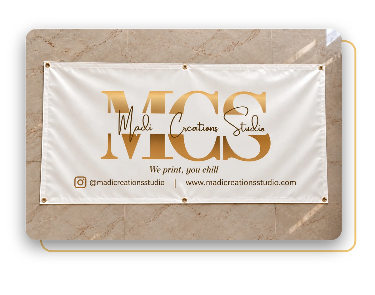 Madi Creations Studio vinyl banner printed with the MCS logo, hung on a marble wall
